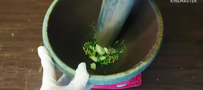 Pound 3 galangal roots, 3 coriander roots, 1 teaspoon peppercorns, and 4 garlic cloves.