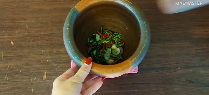 Pound the roasted chilies, garlic, and shallots until fine.