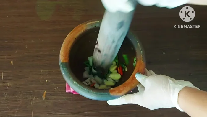 Pound the chili peppers, shallots, and garlic together.