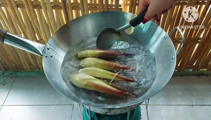 Blanch the banana blossom in hot water. (Optional: You can soak it in lemon juice to soften it.)