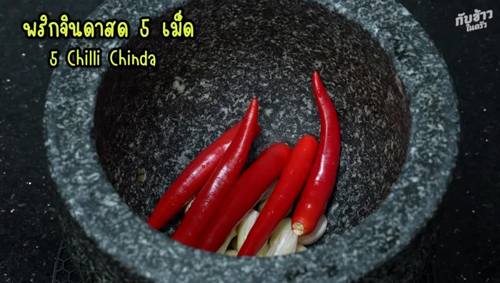 Pound garlic and chili peppers in a mortar until roughly crushed. (You can add peppercorns for extra spice.)