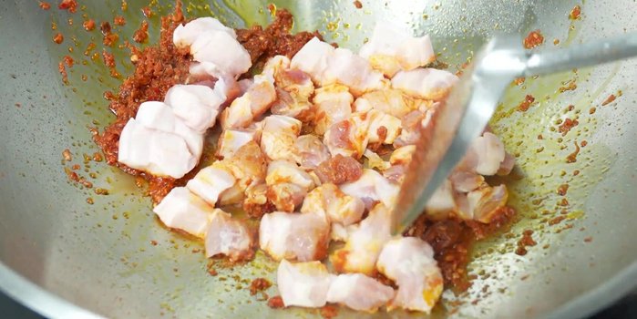 Add pork belly and stir-fry until it starts to cook. Add kaffir lime leaves.