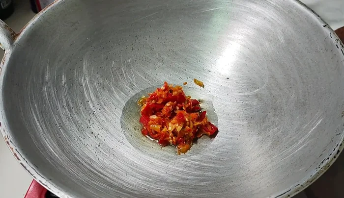 Heat oil in the pan, add chili and garlic, and stir-fry until fragrant.