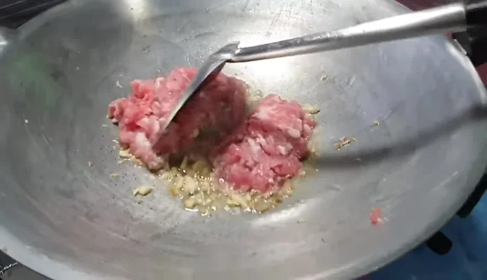Add minced pork and stir-fry until cooked.