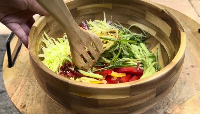 Gently toss the salad, allowing the vegetables to soften slightly and the flavors to meld.