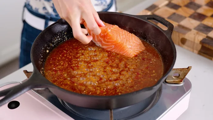 Add salmon skin-side down to the skillet; cook for 2 minutes, spooning sauce over the salmon.