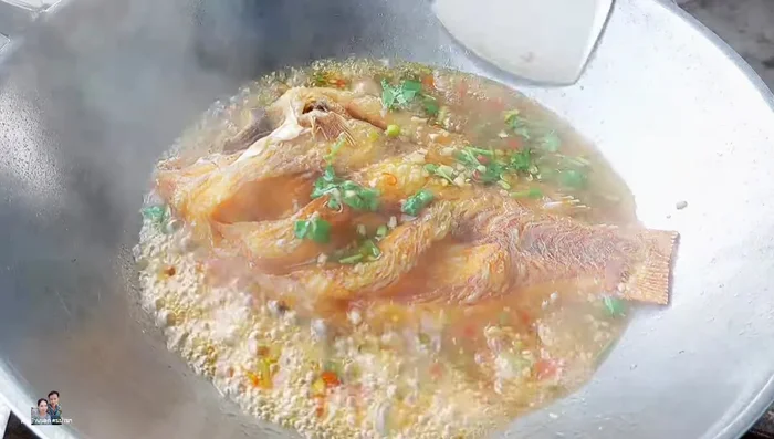Add the fried tilapia to the sauce, gently mixing to coat evenly.