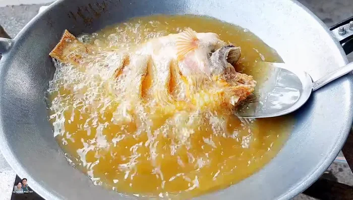 Fry the tilapia until the bottom is yellow. Flip and fry until both sides are golden brown.
