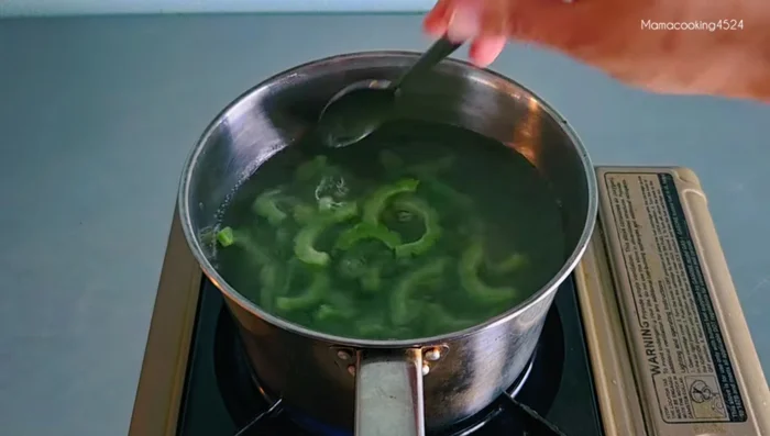 Blanch the bitter melon slices in boiling water with a little salt for 1-2 minutes until the color changes. Immediately transfer to cold water to maintain crispiness.