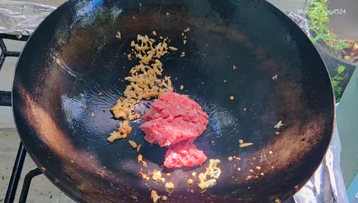 Add minced pork and stir-fry until cooked.