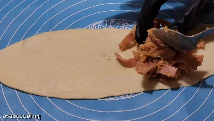 Fill and roll: Spread the pork floss bologna filling on the dough sheet, then roll it up tightly, sealing the edges.