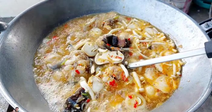 Add cha-om (50g), betel leaves (1g), dried basil, and chili peppers. Simmer until the fish is cooked through and the mushrooms are tender.