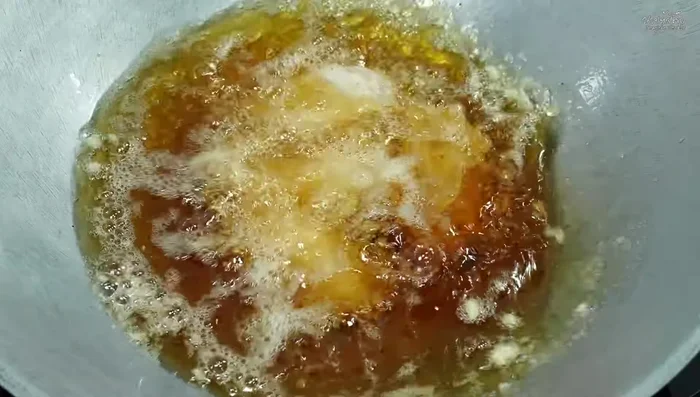 Fry chicken wings in batches, ensuring they don't overcrowd the pan. Fry until golden yellow.