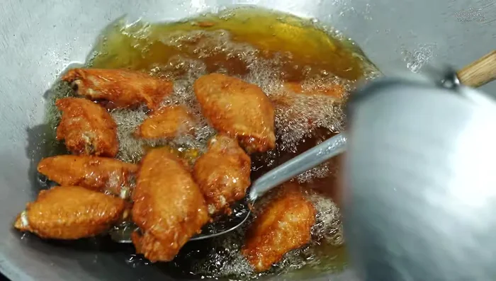 Remove chicken wings and drain excess oil using a strainer, sieve, or oil blotting paper.