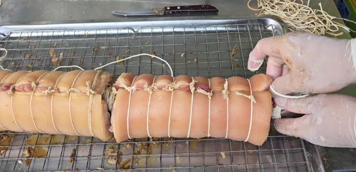 Tie the pork belly securely using string or rope.