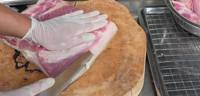 Trim the pork belly to a manageable size for tying.