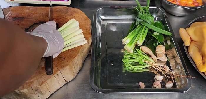 Prepare herbs: pandan leaves, lemongrass, kaffir lime leaves, coriander, and crushed garlic.