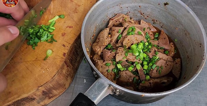Add chopped spring onions, Thai chilies, shallots, and neem leaves.