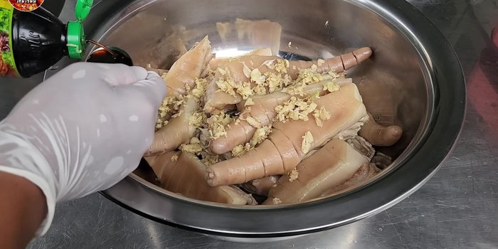 Prepare the marinade: coarsely pound garlic, add pepper, coriander root, oyster sauce, palm sugar, pork seasoning powder, salt, and sugar. Mix well. (109.14)