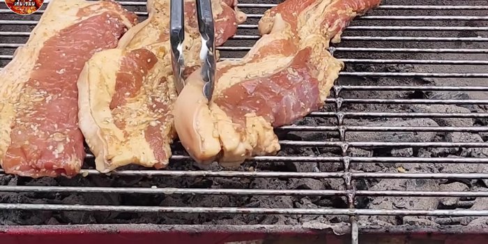Grill the pork over medium heat. Use charcoal for a smoky flavor or gas for convenience. A smoke extractor is recommended for gas grilling.