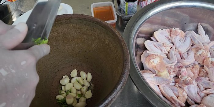 Prepare the herb mixture: Pound 1.5 tablespoons of white peppercorns, 100 grams of garlic, 7-8 coriander roots, and 3 lemongrass stalks.