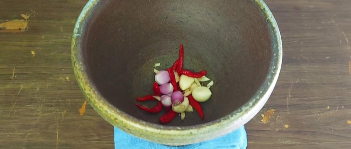 Pound the dried chilies, garlic, shallots, and salt in a mortar and pestle until finely ground.