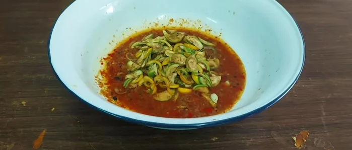 Add the eggplant to the curry paste, followed by the pork rinds and canned fish (shredded or chopped).