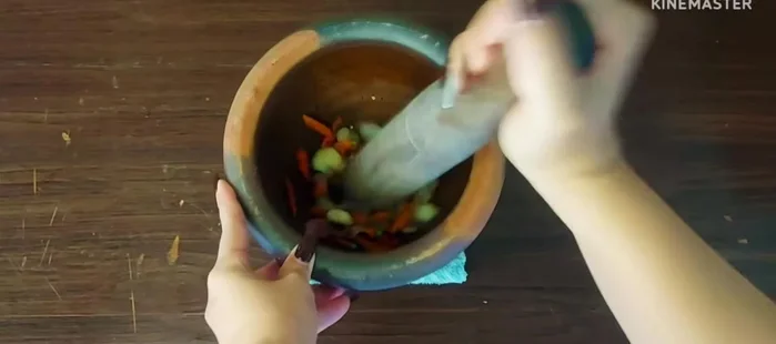 Pound the roasted chilies, shallots, and garlic into a fine paste.