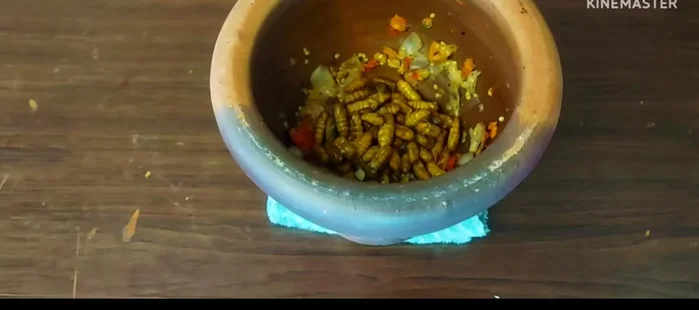 Add the roasted pupae to the paste and pound until fine.