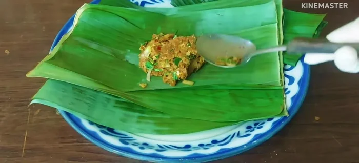 Wrap the pork larb in banana leaves, overlapping several times to prevent burning.