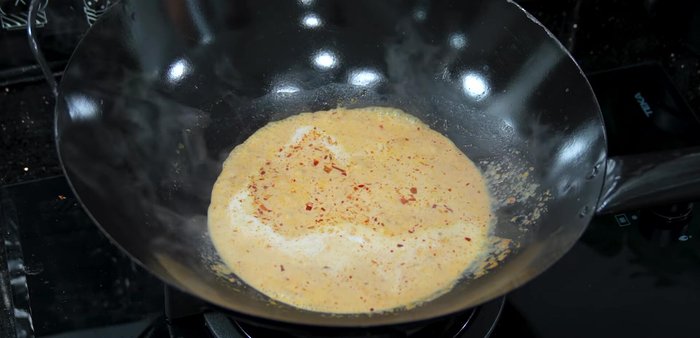 Simmer the mixture until the coconut milk thickens and slightly separates. Avoid high heat to prevent burning.