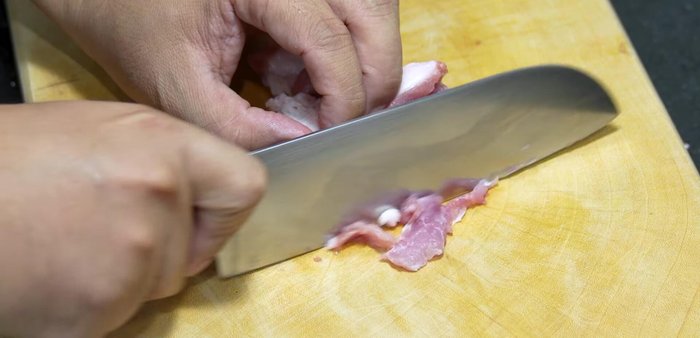 Cut the pork shoulder thinly across the grain, ensuring each piece sticks together.