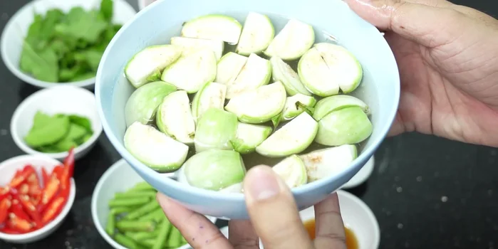 Prepare the eggplant: Cut the eggplant and soak it in salt water to prevent it from turning black.