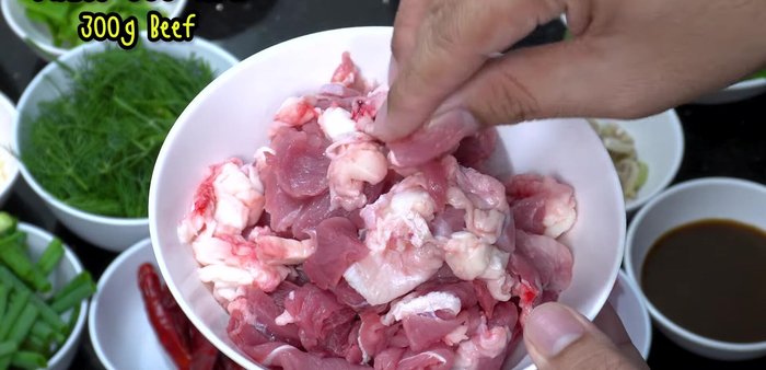 Prepare the ingredients: Slice beef thinly, cut kale and coriander into sections, tear kaffir lime leaves, and chop spring onions.