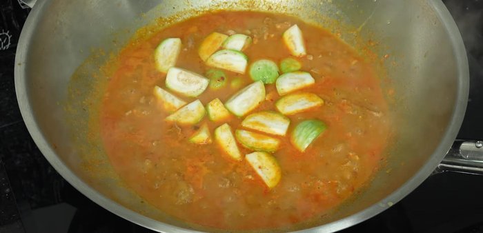 Add the prepared eggplant, bell peppers, and red chili peppers. Simmer until the eggplant is cooked but not mushy.