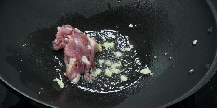 Add the marinated pork and stir-fry until cooked.