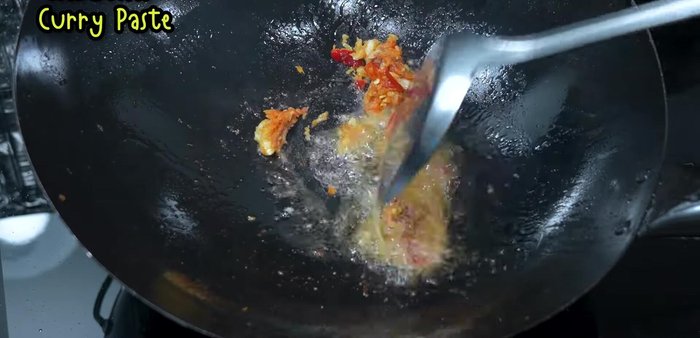 Add the pounded garlic, chili, and shrimp paste mixture to the wok and stir-fry until fragrant (279.84).