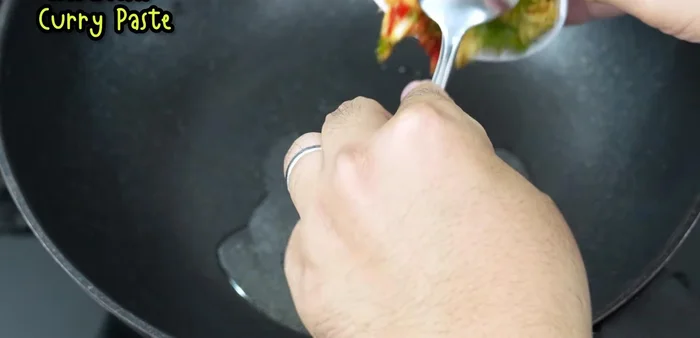Heat oil in a wok or frying pan over high heat. Stir-fry the pounded ingredient paste until fragrant and slightly yellow.