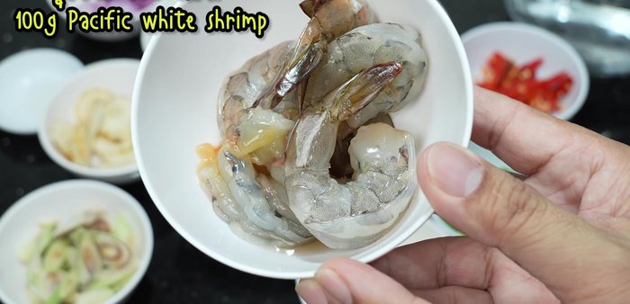 Clean and prepare the shrimp and squid: remove shells, veins, and cut into pieces.