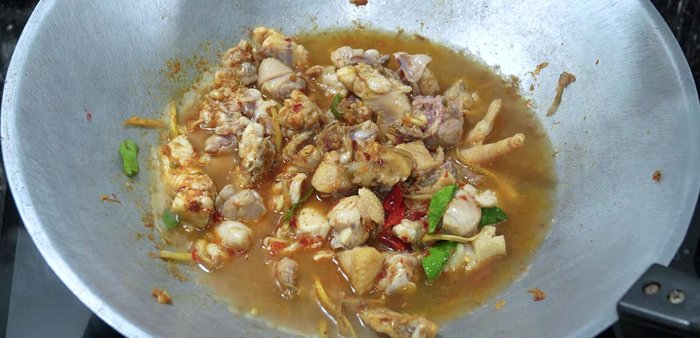 Add mortar washing water (water used to rinse the mortar after preparing the curry paste) and simmer until chicken is tender.