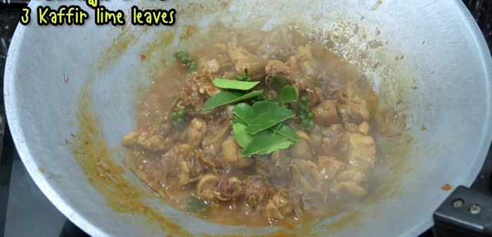 Add vegetables (young pepper, kaffir lime leaves, chili peppers), stir-fry until cooked.