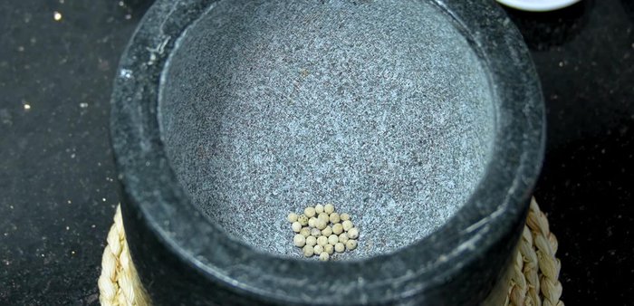 Pound the spices: In a mortar and pestle, pound white peppercorns, red chili peppers (optional), garlic, and shrimp paste until finely crushed.