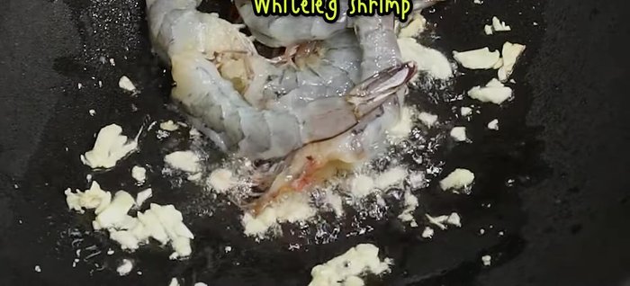 Add yellow onions, then white shrimp (peeled and deveined). Stir-fry over medium-high heat until shrimp is cooked through but not overcooked.