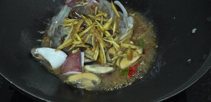Sprinkle chopped galangal, torn kaffir lime leaves, and young peppercorns. Stir-fry until cooked through. Add more chili if desired.