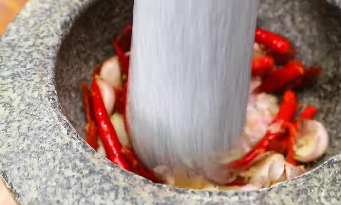 Mince the garlic and chilies. Chop the holy basil.