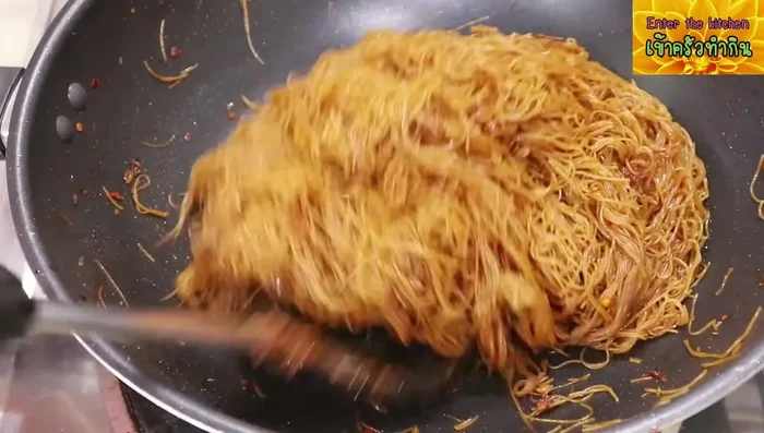 Pour the sauce over the noodles and stir-fry until evenly coated.