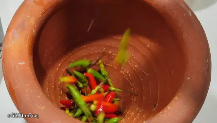 Pound the chili peppers to your desired level of spiciness.