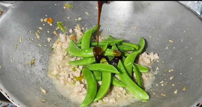 Add the sweet peas, oyster sauce, seasoning sauce, light soy sauce, and granulated sugar (optional). Add seasoning powder or MSG (optional).