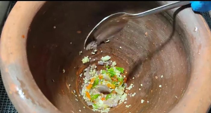 Add 1 teaspoon of shrimp paste and continue to pound all ingredients until fine.
