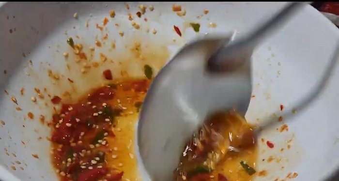 Combine the cooked instant noodles, vegetables (except chives), and the spicy salad dressing.